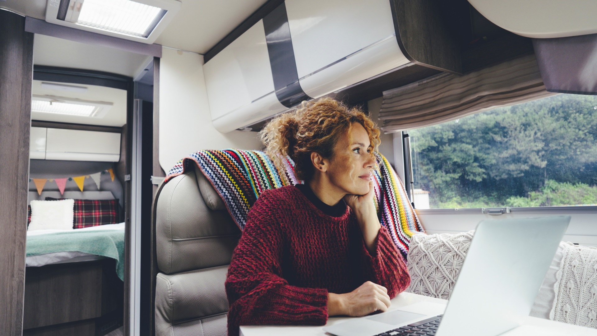 Tips for long term camping. Adult woman use laptop computer inside a camper van. Southern Comfort RV Park.